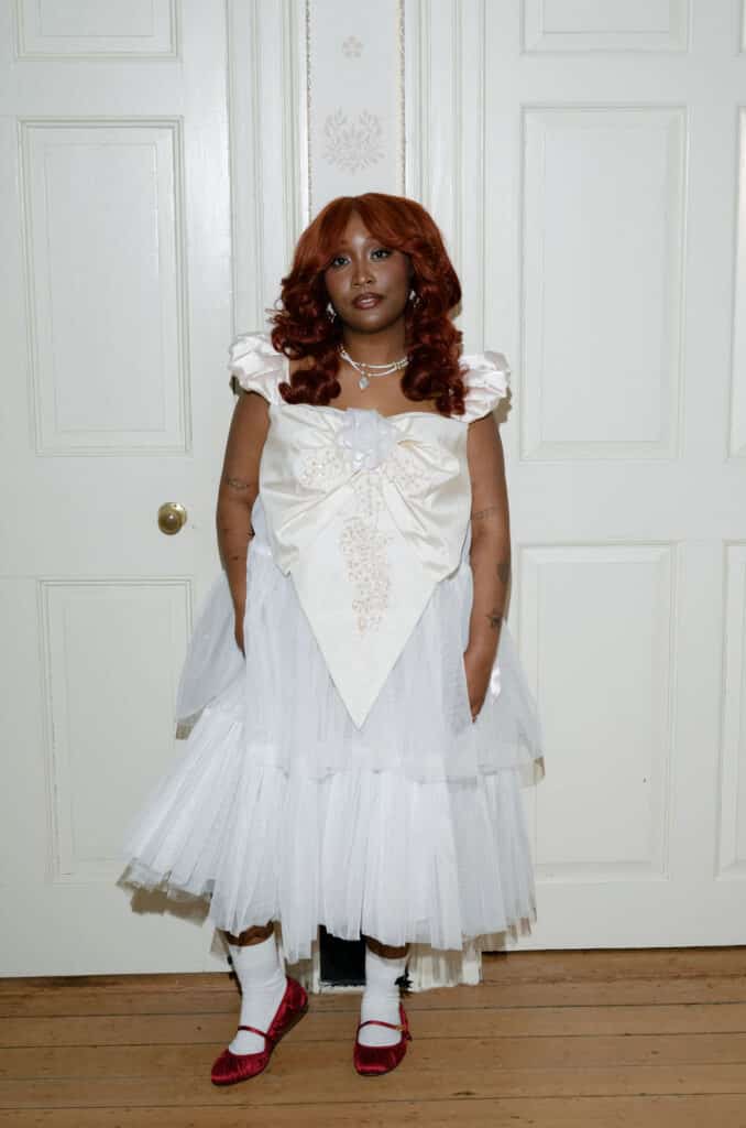 Person in white dress and red shoes